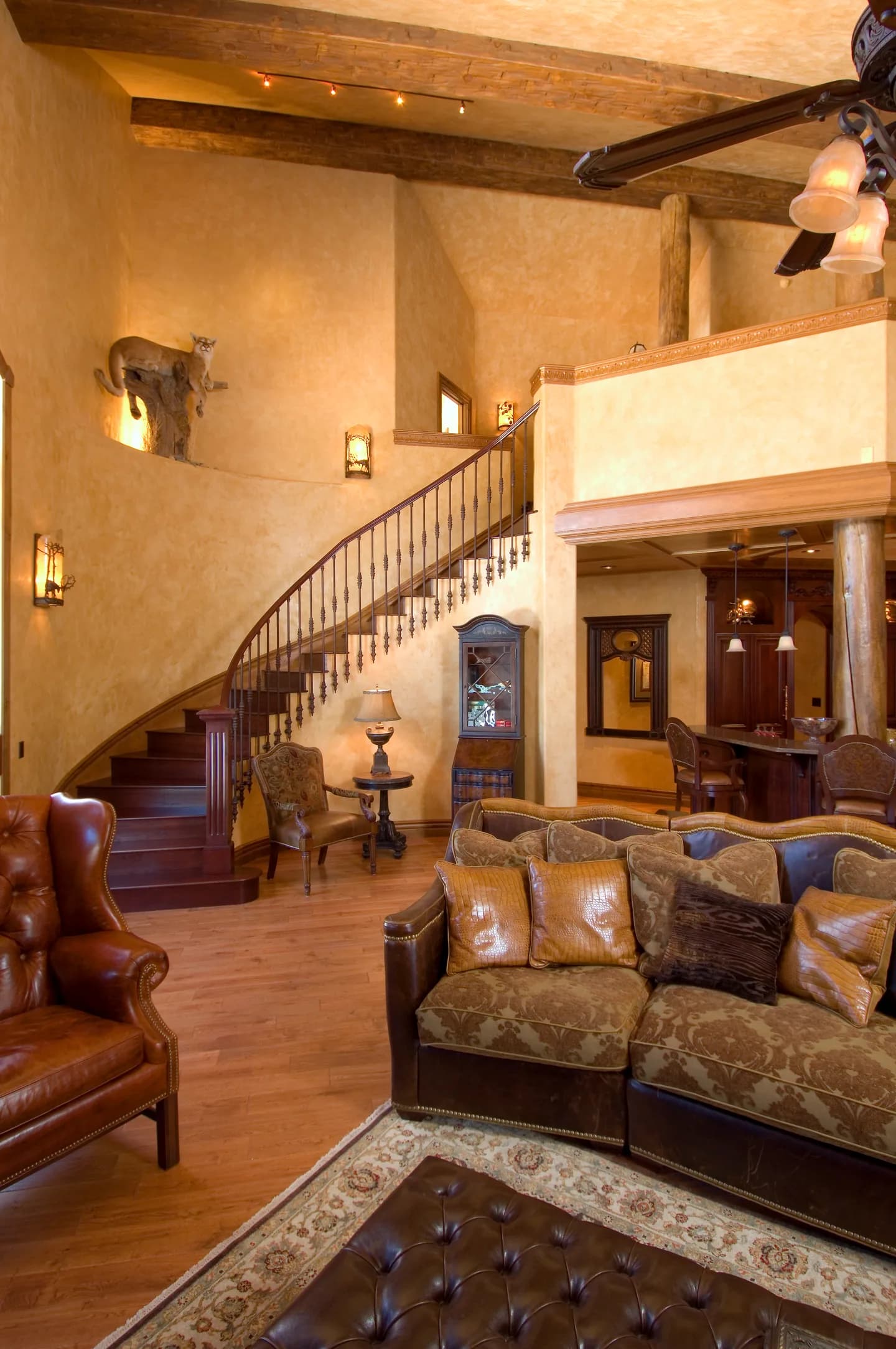 Remodeled two-story great room with a curved staircase and exposed beams, part of a whole-home Stauffer & Sons remodel