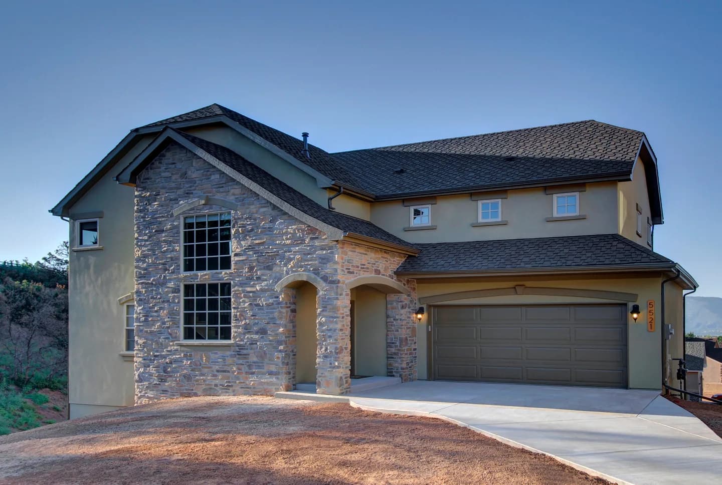 Two-story custom home with full stone front elevation, arched entry and attached three-car garage.